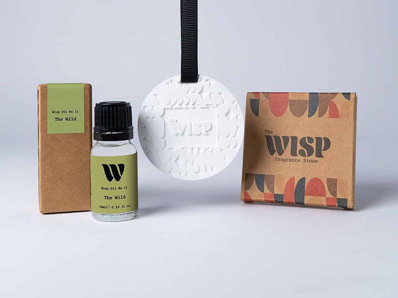 Bottle of the 10ml Wisp home fragrance oil No.11 The Wild which has notes of floral lily of the valley and persimmon, with a premium wisp branded fragrance stone to hang in car or wardrobe. The perfect small gift.