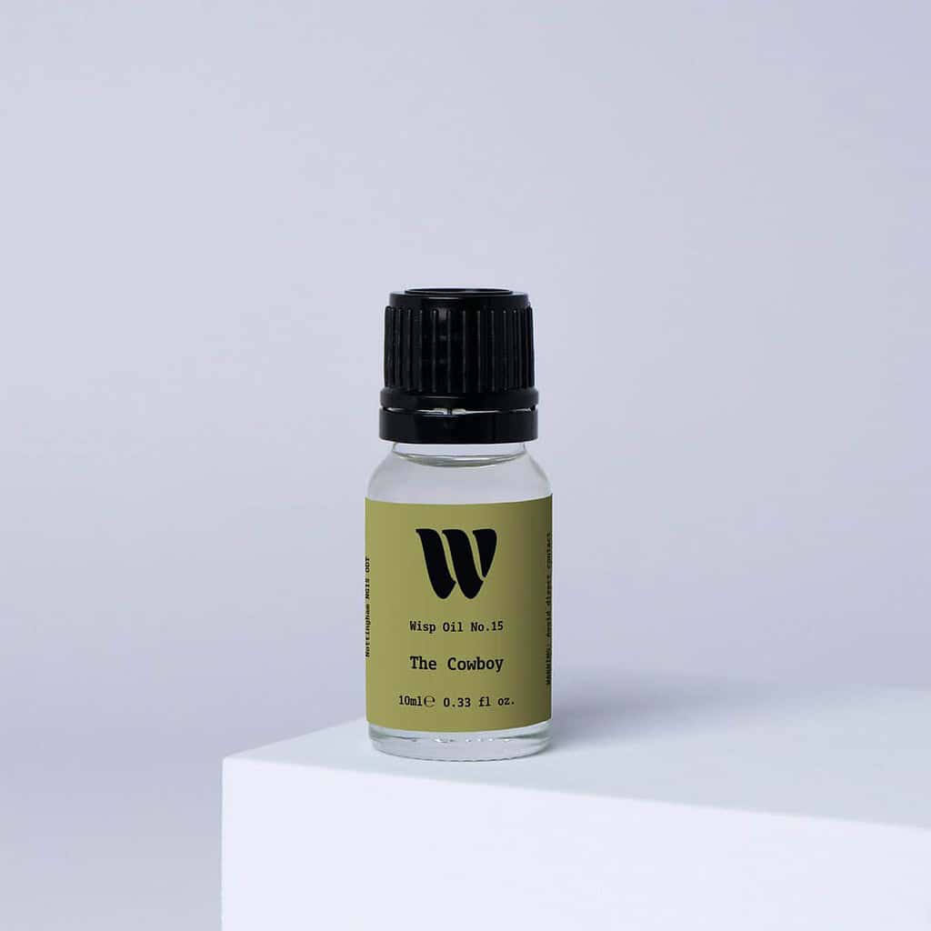 Bottle of the 10ml Wisp home fragrance oil No.15 The Cowboy which has notes of sandalwood and cedarwood.