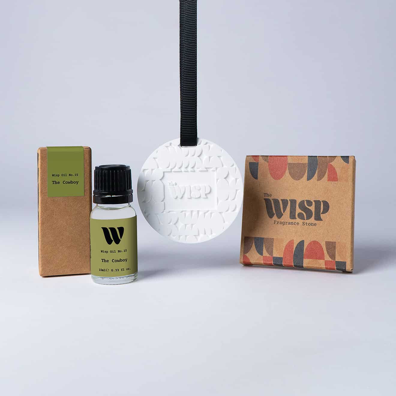 Bottle of the 10ml Wisp home fragrance oil No.15 The Cowboy which has notes of sandalwood and cedarwood, with a premium wisp branded fragrance stone to hang in car or wardrobe. The perfect small gift.