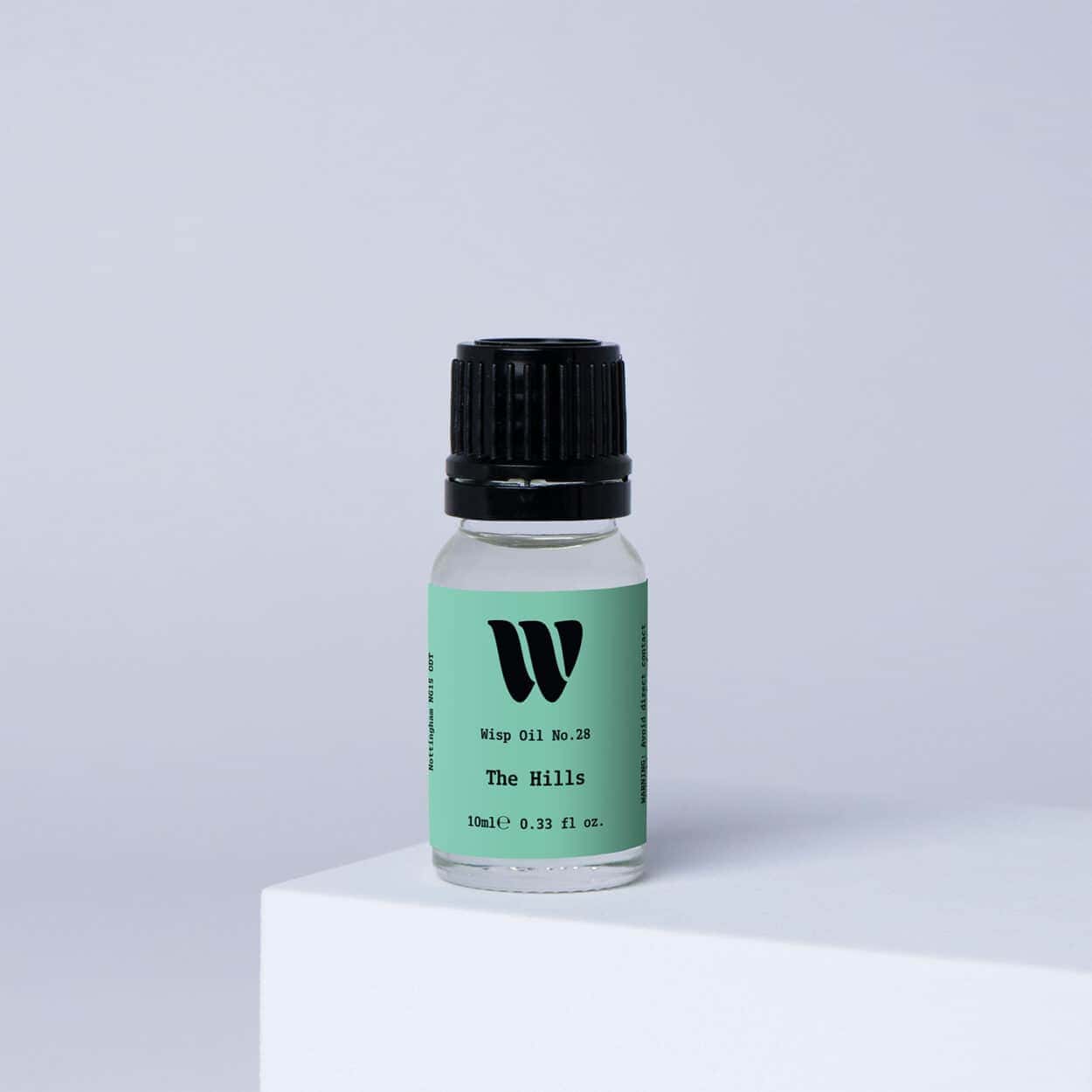 Bottle of the 10ml Wisp home fragrance oil No.28 The Hills which has notes of citrus, tea and cedarwood.