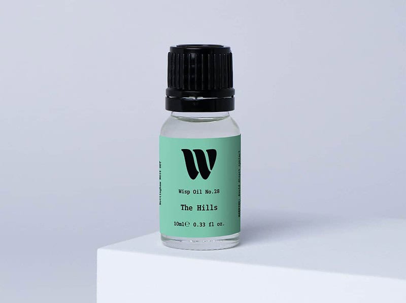 Bottle of the 10ml Wisp home fragrance oil No.28 The Hills which has notes of citrus, tea and cedarwood.