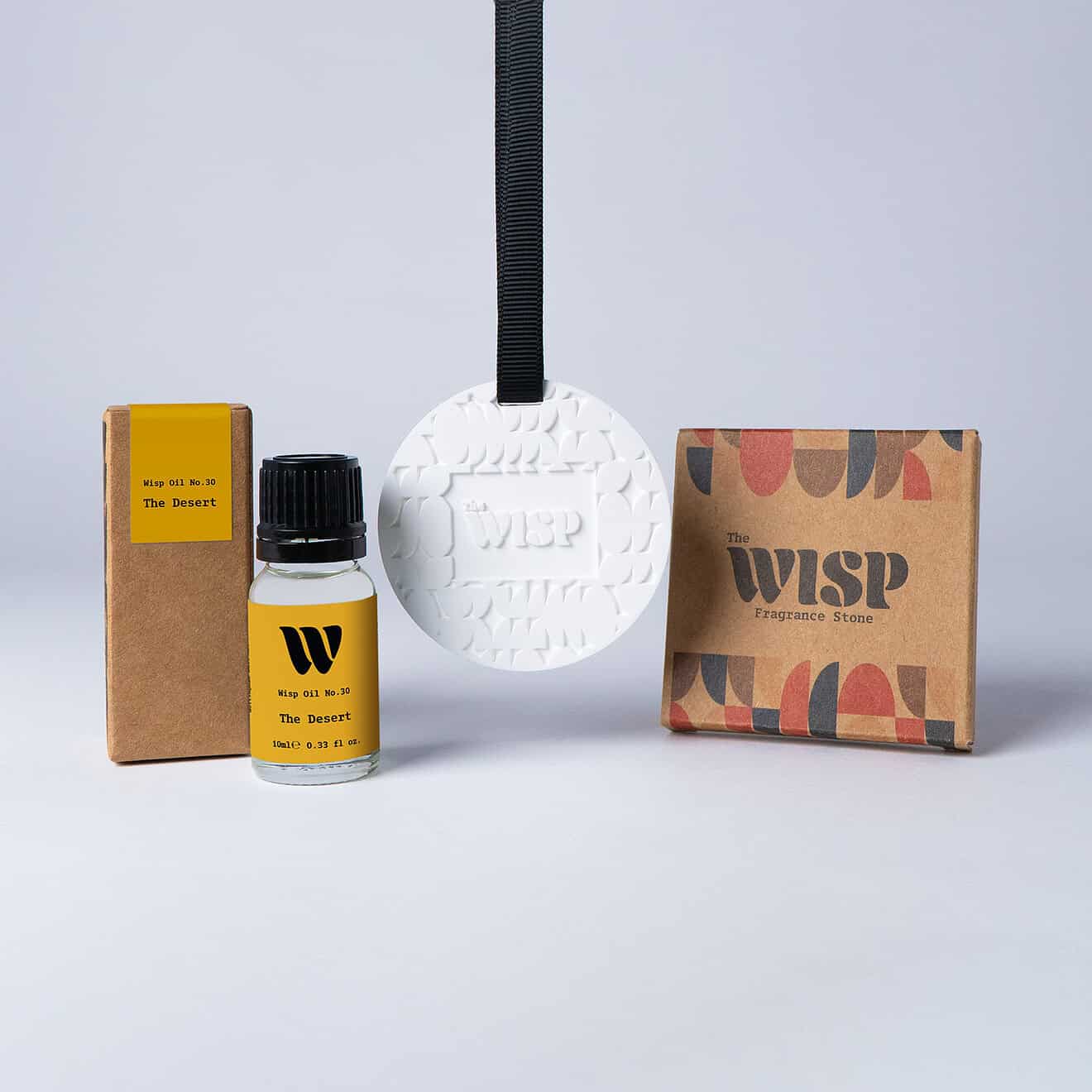 Bottle of the 10ml Wisp home fragrance oil No.30 The Desert which has notes of mandarin and Californian lemon, with a premium wisp branded fragrance stone to hang in car or wardrobe. The perfect small gift.