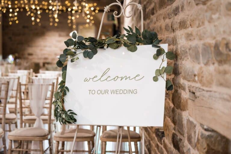 The scent of your wedding day, kept 1 A barn wedding venue with a welcome sign, eucalyptus and fairy lights